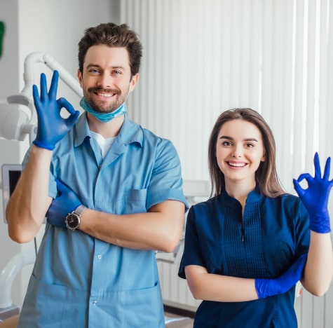 a man and woman in blue scrubs and gloves